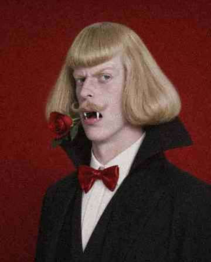 Jean Phil holding a rose in his fangs